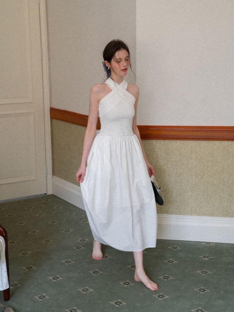 Woman wearing a white sleeveless halter midi dress