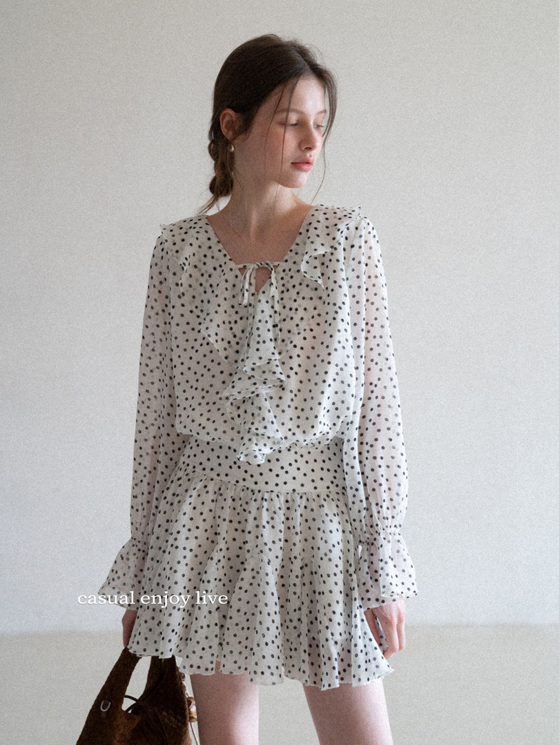 Model wearing a white polka dot ruffle dress with long sleeves