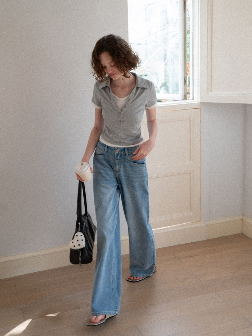 Model wearing a gray short-sleeve knit top with light blue flared jeans and sandals