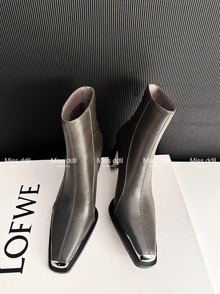 Pair of metallic ankle boots displayed on a white surface