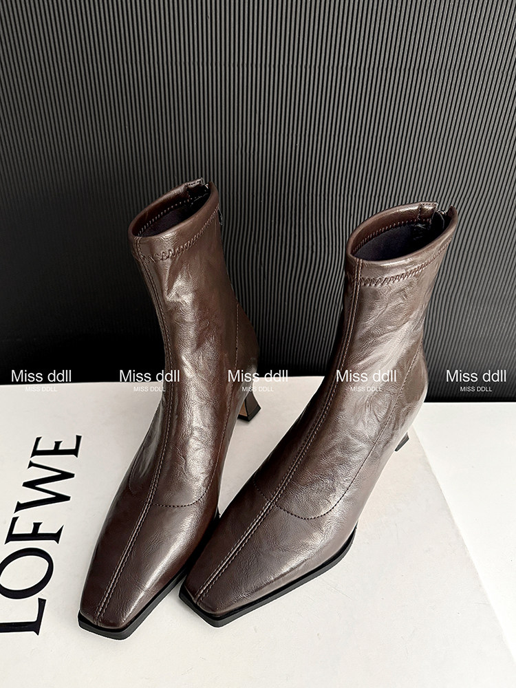Brown leather ankle boots on a display surface