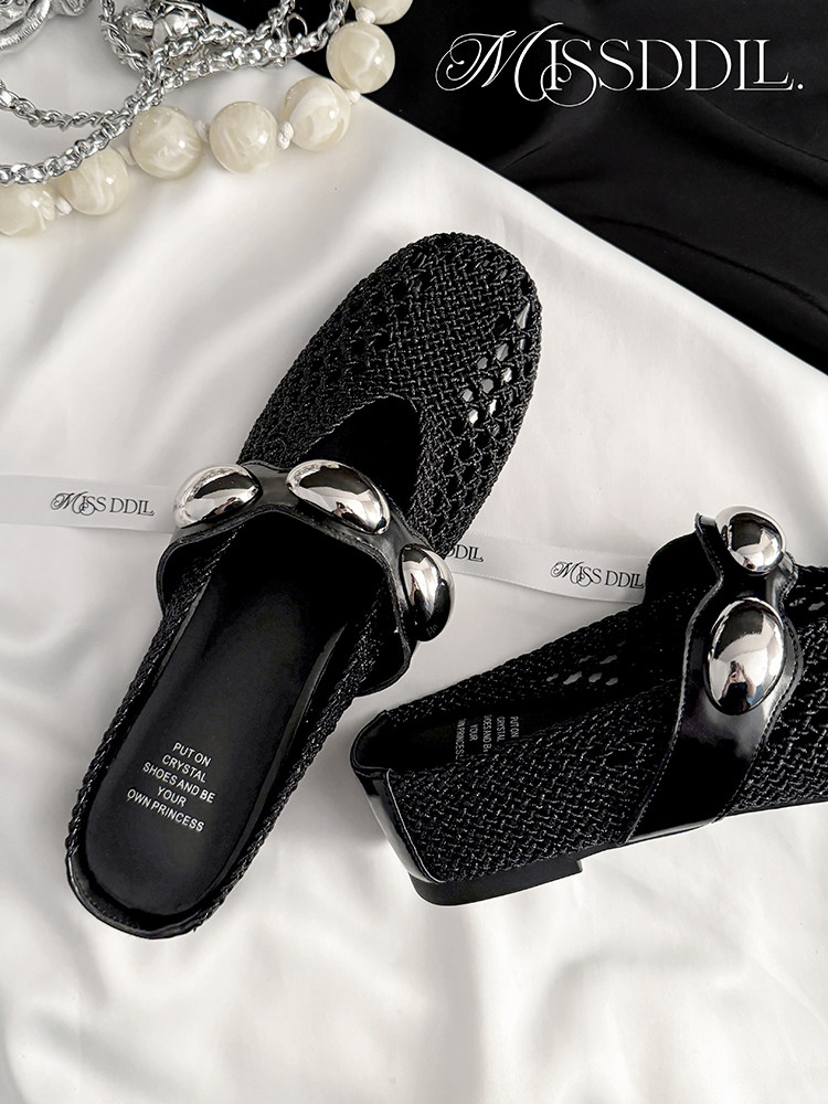 Black woven slip-on shoes with silver embellishments shown on a white background