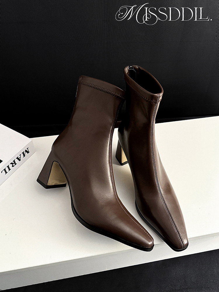 Brown pointed-toe heeled ankle boots on display