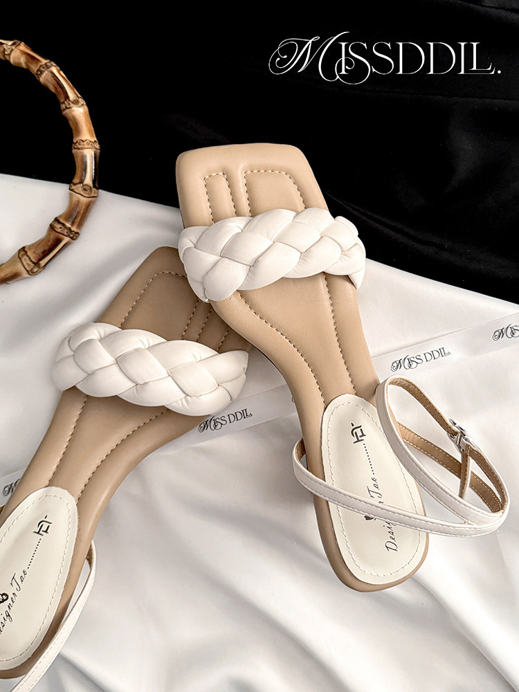 Pair of beige and white braided strap flat sandals