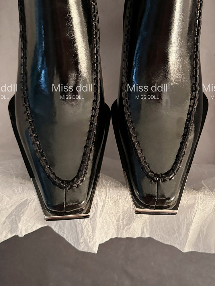 Black glossy loafers or dress shoes photographed up close