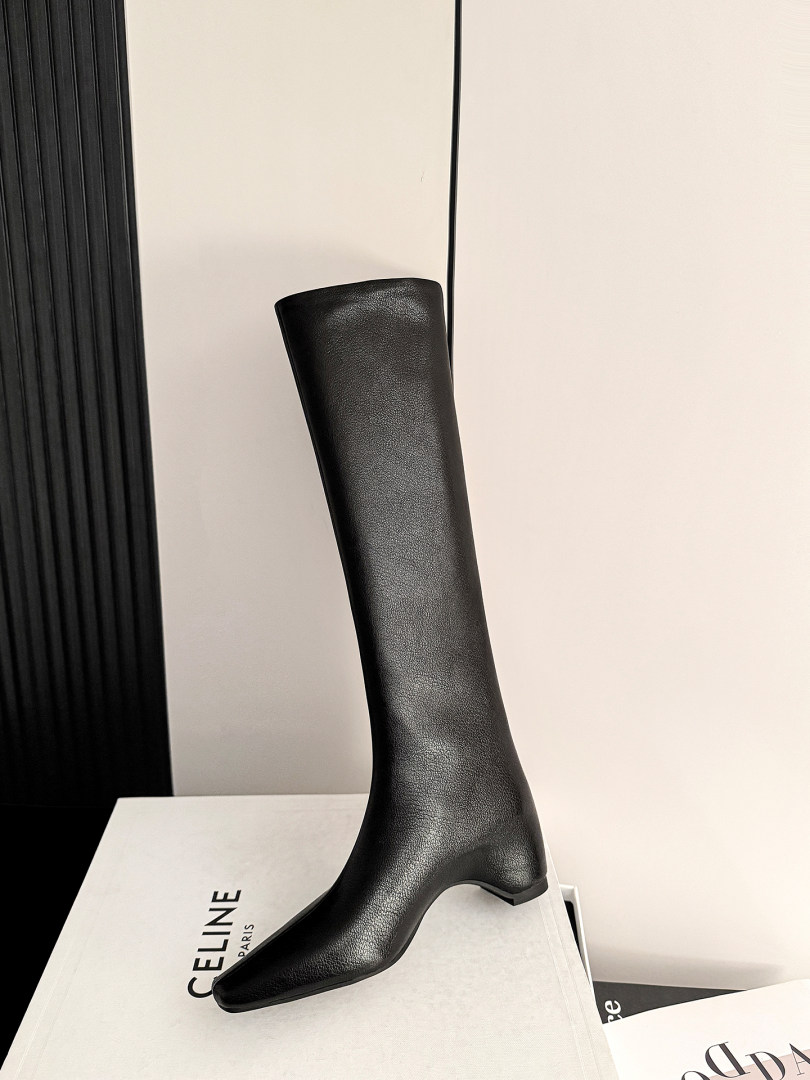 Black knee-high leather boot displayed on a box