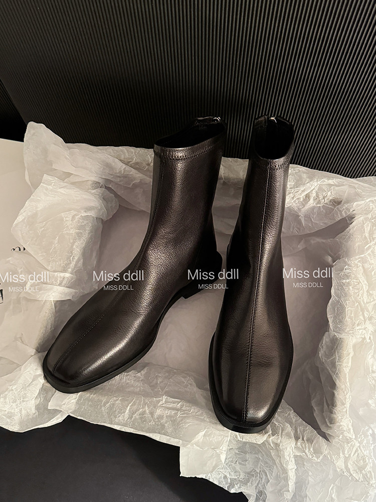 Pair of black leather ankle boots on tissue paper
