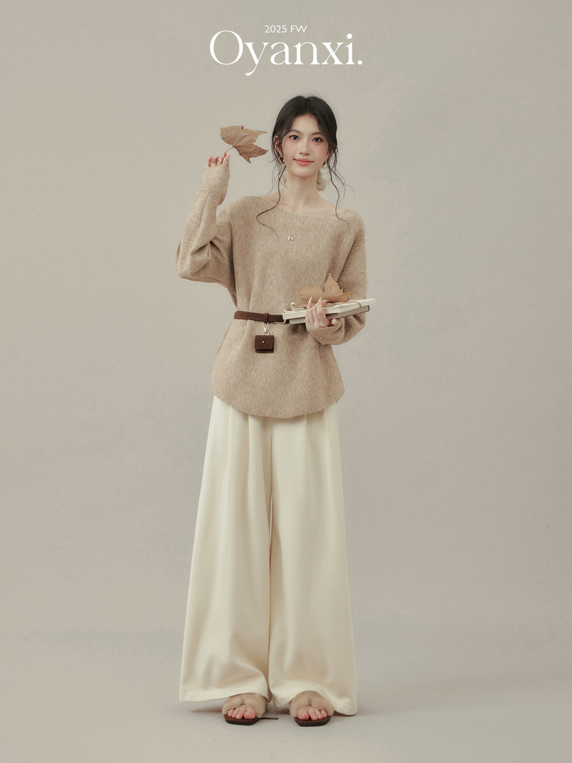 Model wearing a beige knit top and cream wide-leg pants on a neutral background