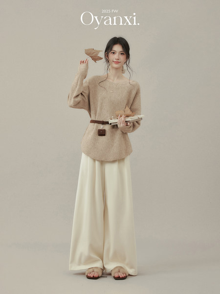 Model wearing a beige knit top and cream wide-leg pants on a neutral background