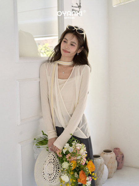 Model wearing a cream sheer layered long-sleeve top and skirt