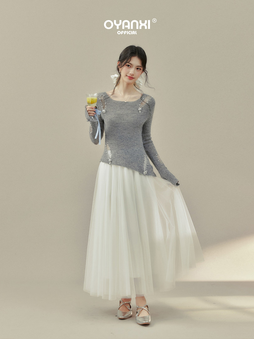 Model wearing a grey knit top with a white tulle midi skirt and silver flats