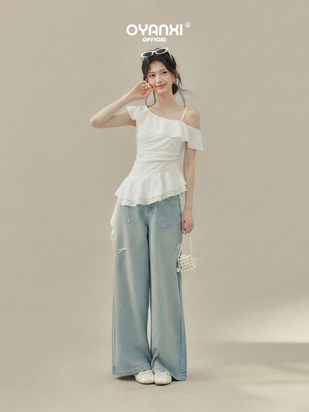 Model wearing a white off-shoulder top with light blue wide-leg jeans