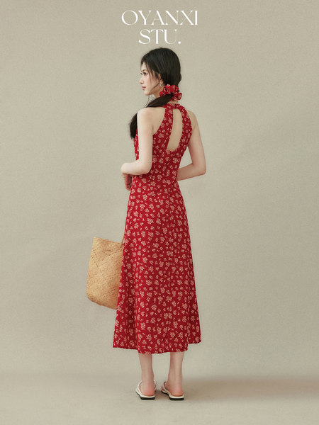 Model wearing a red floral halter midi dress with a back cutout