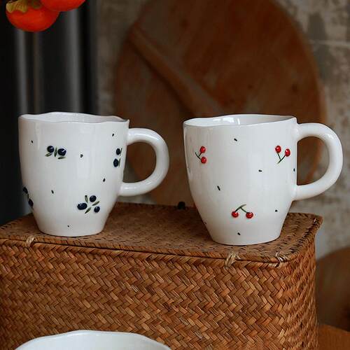 Cherry patterned ceramic tea cups, dessert bowls, and plates