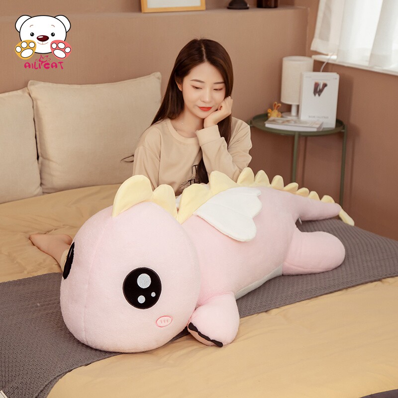 여아용 공룡 베개는 여자친구가 퀸 사이즈 침대에 붙잡고 있는 봉제 장난감 봉제 장난감 인형에서 자고 있습니다