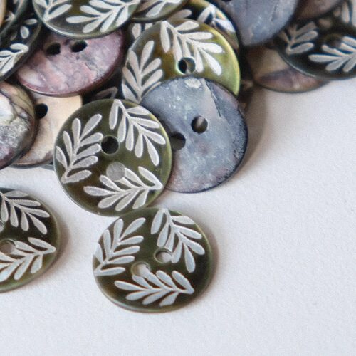 白色枝叶深暗绿色底贝壳纽扣