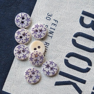 白底蓝紫色流星花镭射图河贝纽扣