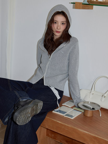 Model wearing a gray zip-up hooded sweatshirt