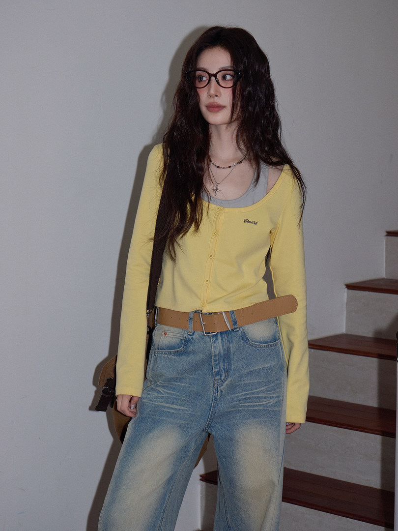 Model wearing a yellow cardigan top with jeans and a belt