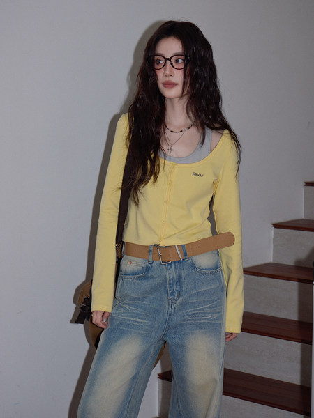 Model wearing a yellow cardigan top with jeans and a belt
