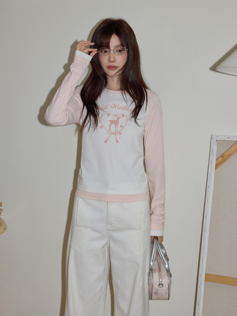 Pastel pink and white long-sleeve top with wide-leg pants worn by a model