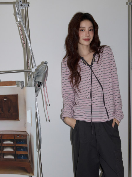 Model wearing a pink striped long-sleeve top with black pants