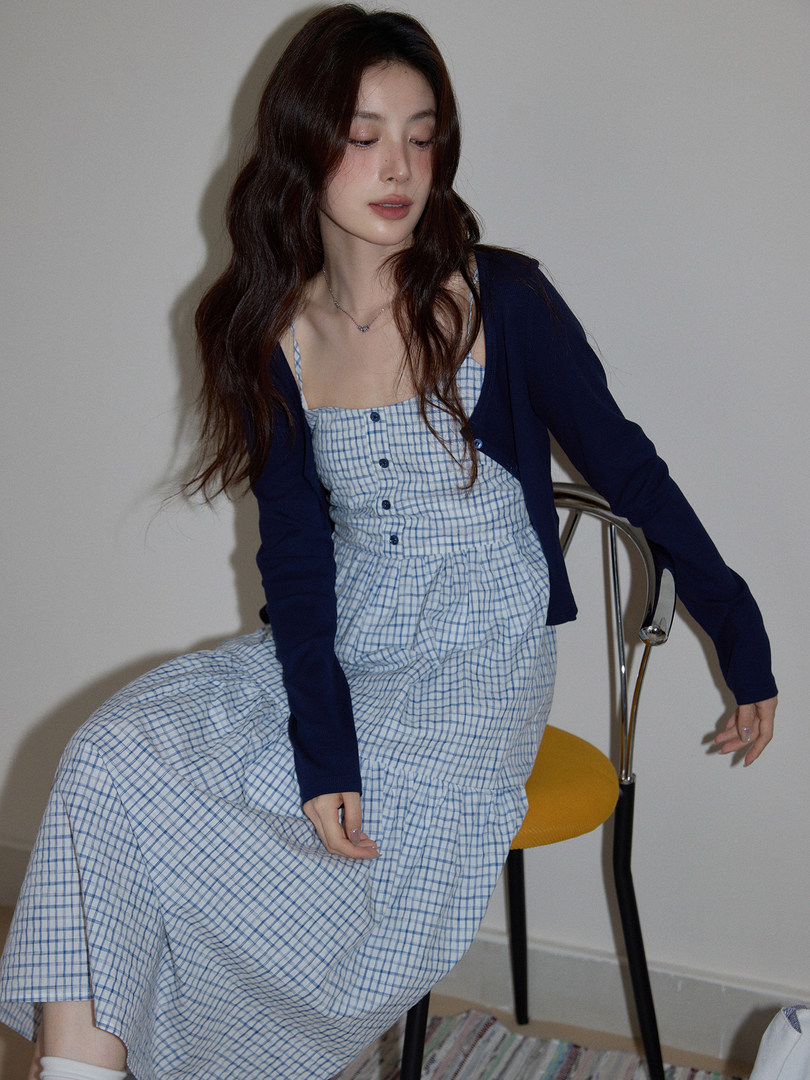Model wearing a blue gingham sundress with a navy cardigan