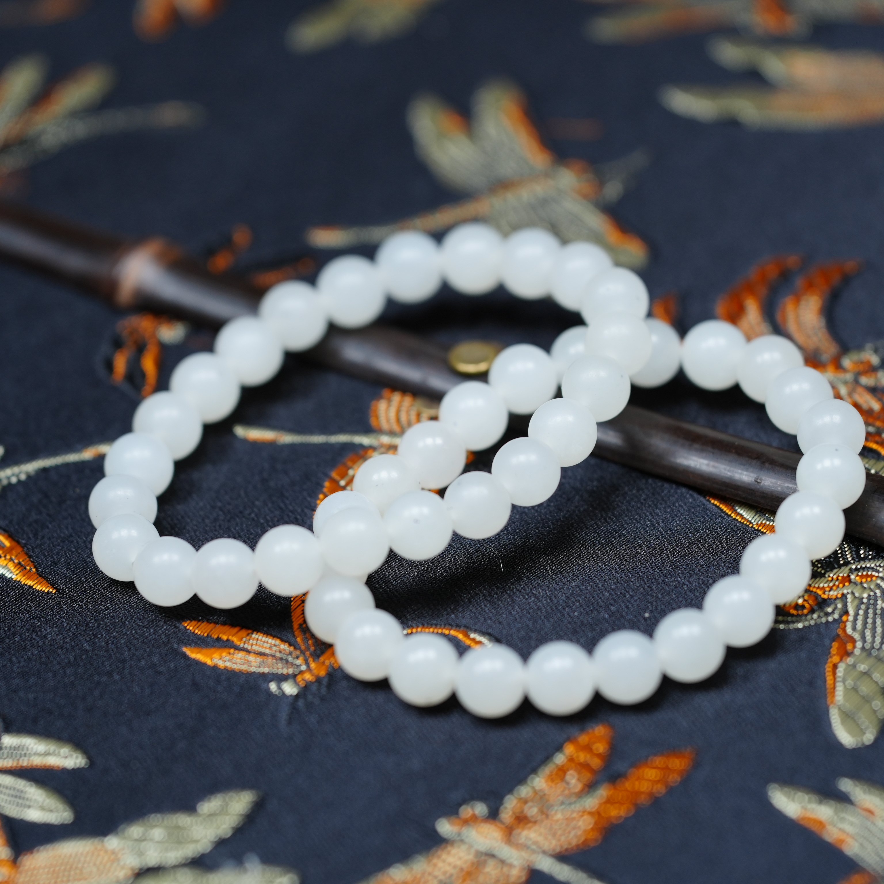 点墨玉染。新疆青花籽料和田玉点墨8毫米一级白羊脂玉手链串