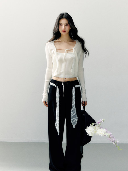 Model wearing a white lace-trim long-sleeve top with black wide-leg pants