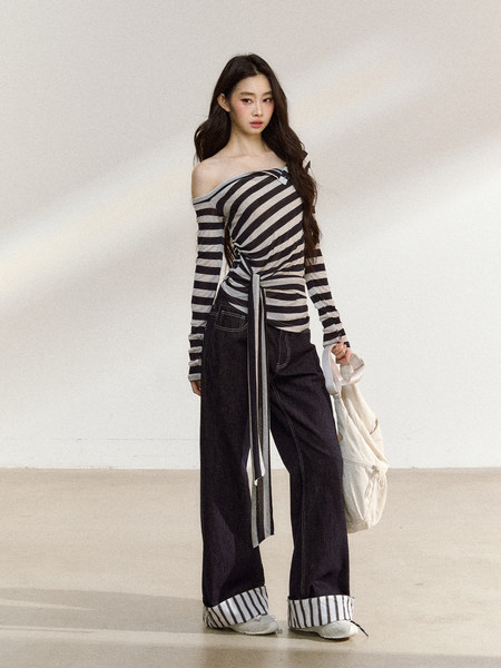 Model wearing a black-and-white striped off-shoulder top with wide-leg pants