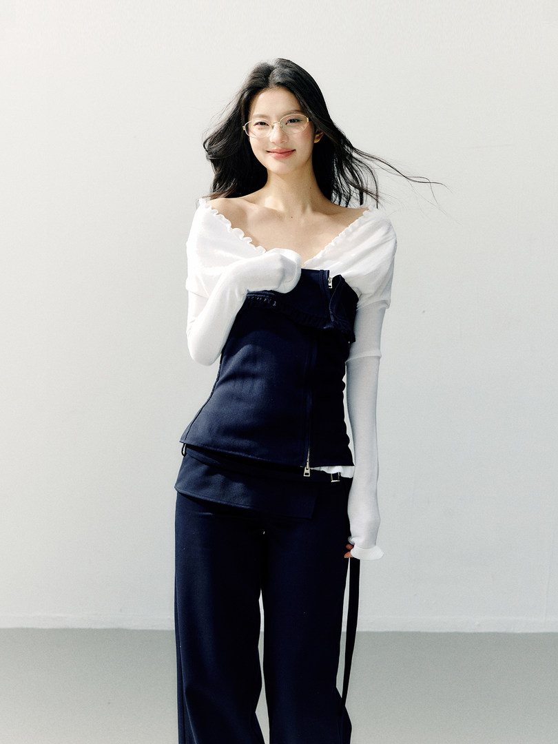 Model wearing a white off-shoulder top with a navy layered wide-leg outfit