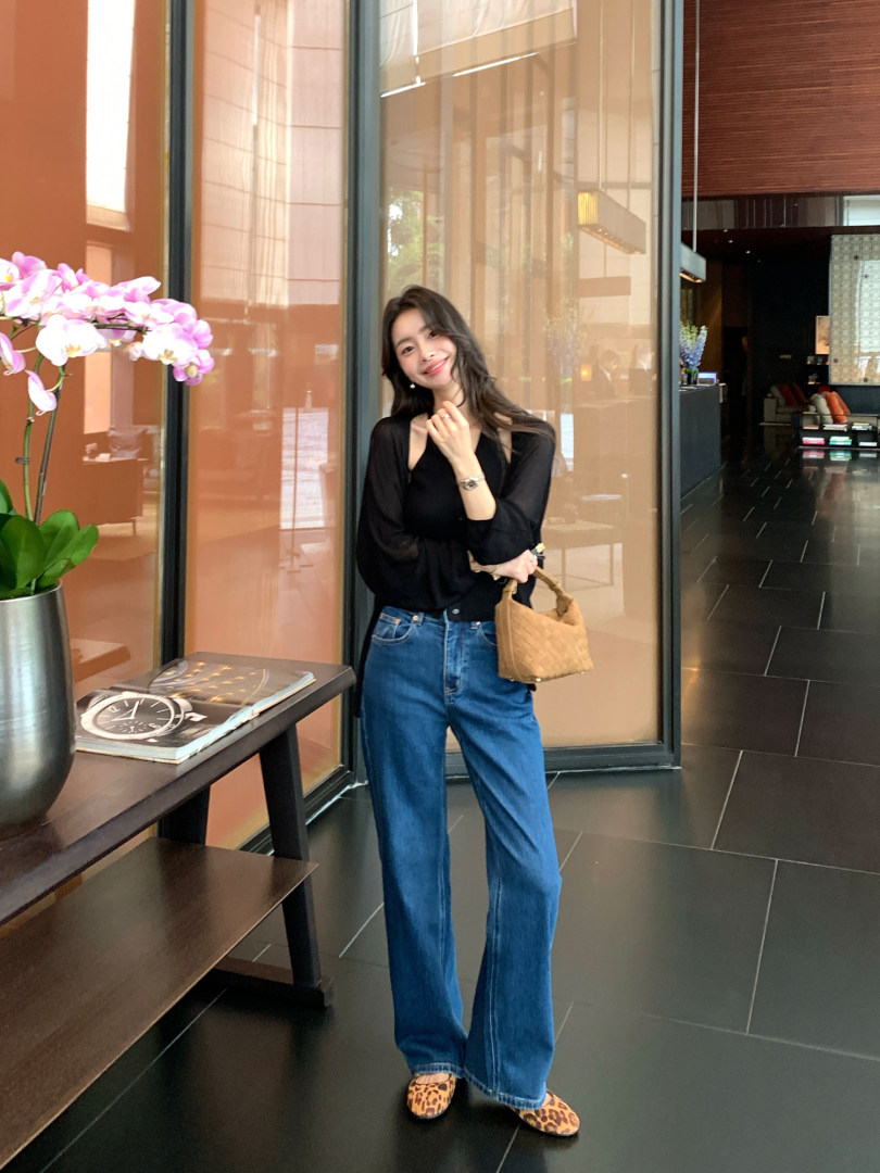 Woman wearing a black top with blue jeans and leopard-print shoes