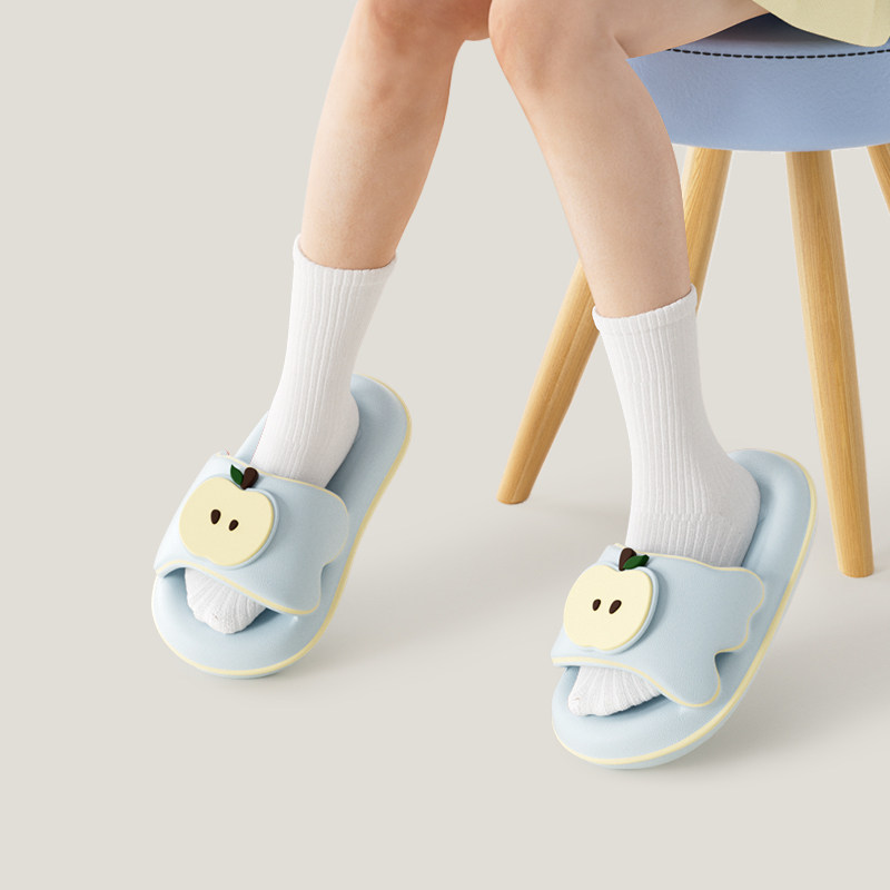 Light blue apple-decorated slippers worn with white socks