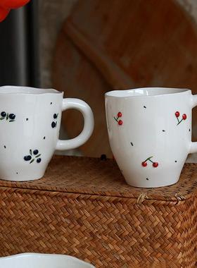 Cherry patterned ceramic tea cups, dessert bowls, and plates