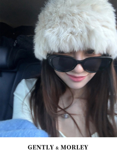Woman wearing a white faux fur hat and black sunglasses