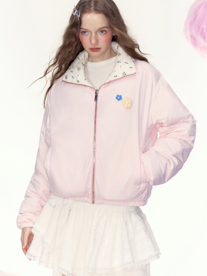 Model wearing a pink zip-up jacket with floral collar and flower patches
