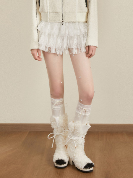 White fuzzy lace-up boots worn with a light outfit on a model