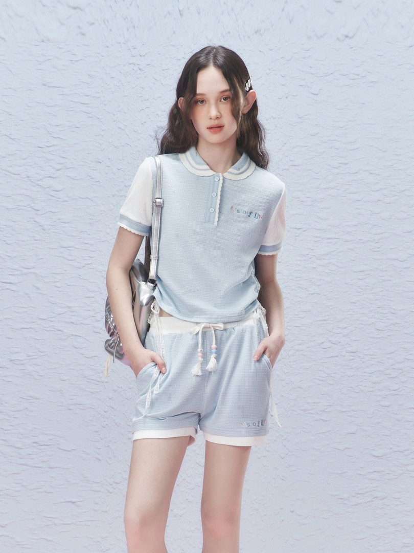 Model wearing a light blue short-sleeve loungewear set with matching shorts
