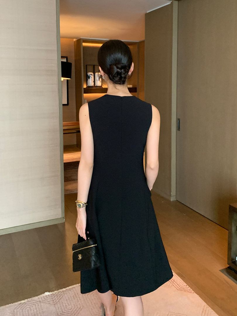 Black sleeveless midi dress worn by a model indoors