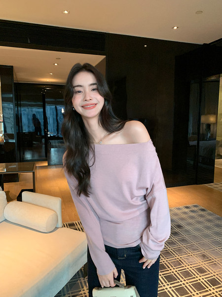 Woman wearing a light pink off-shoulder long-sleeve top with dark jeans