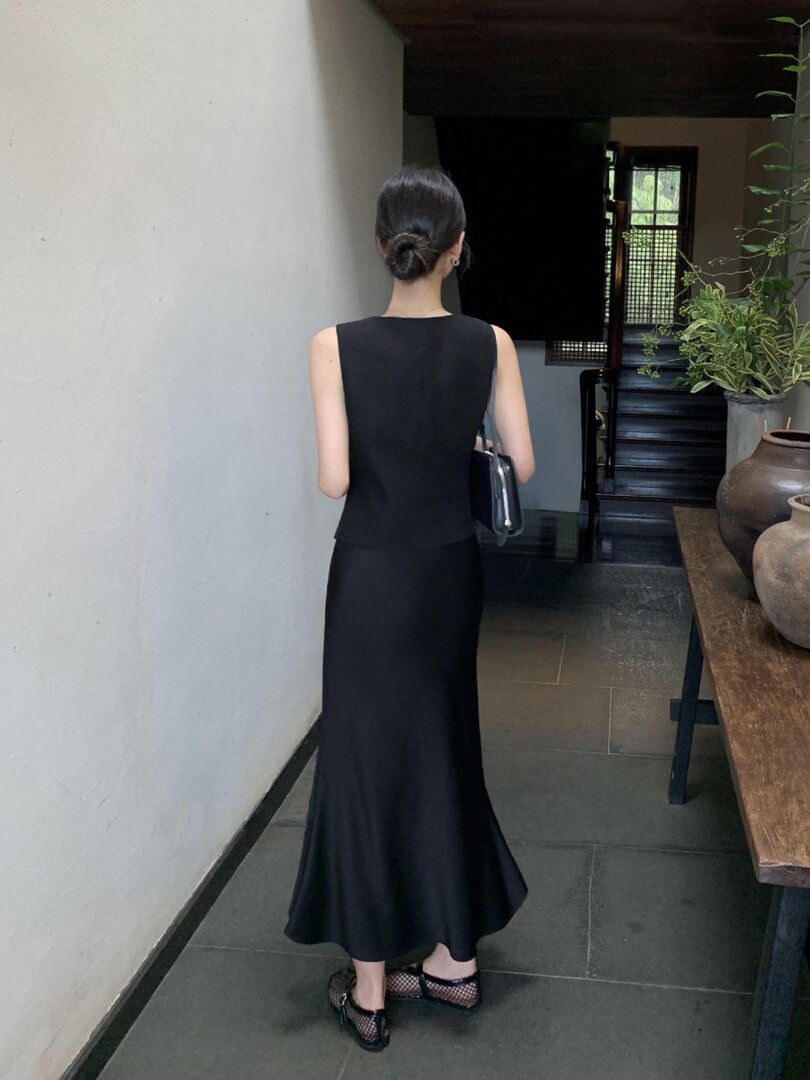 Black sleeveless long dress worn by a model from the back