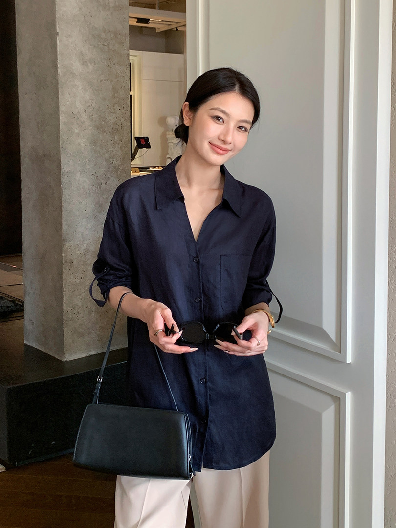 Navy long-sleeve shirt dress worn by a model with a black shoulder bag