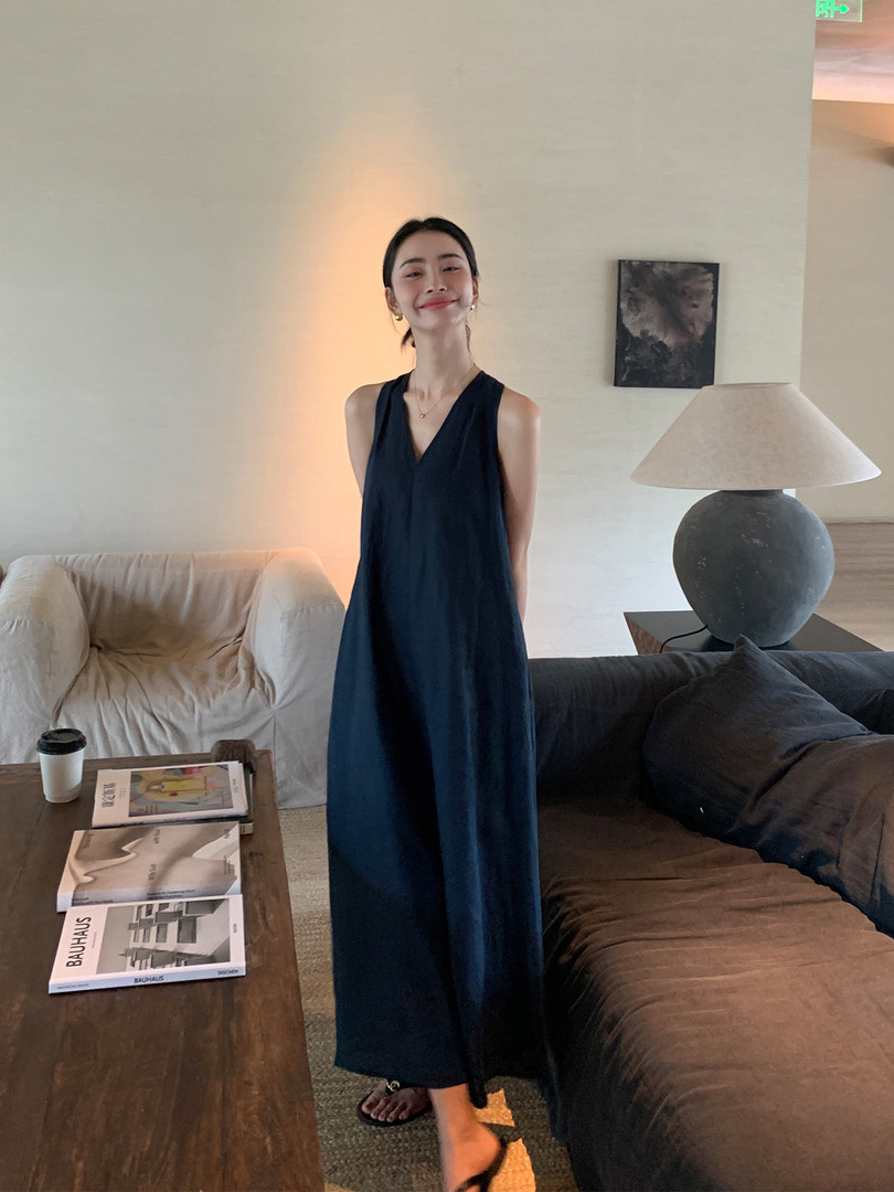 Woman wearing a dark sleeveless long dress indoors