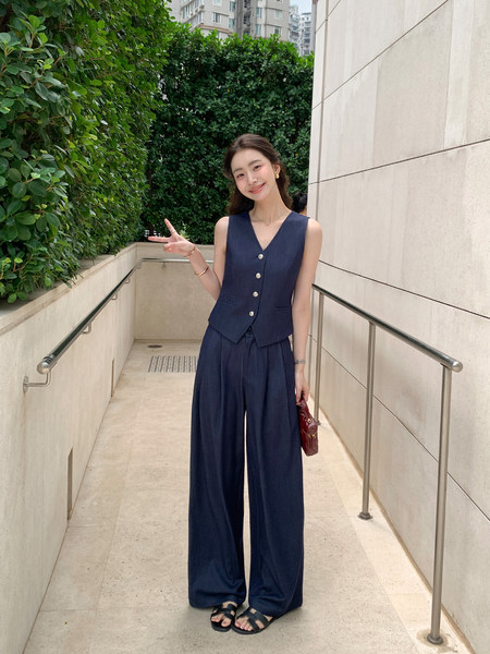 Model wearing a navy sleeveless vest and wide-leg pants set outdoors