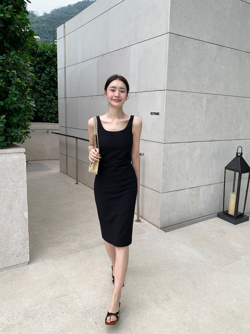 Black sleeveless midi dress worn by a woman outdoors