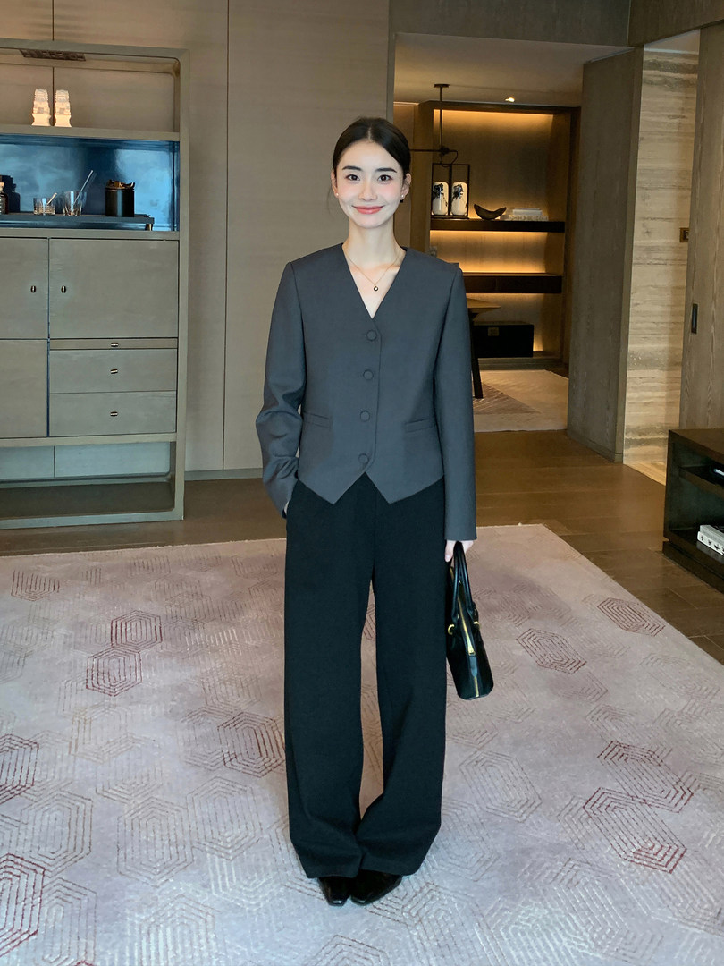 Woman wearing a dark gray tailored blazer with black wide-leg trousers