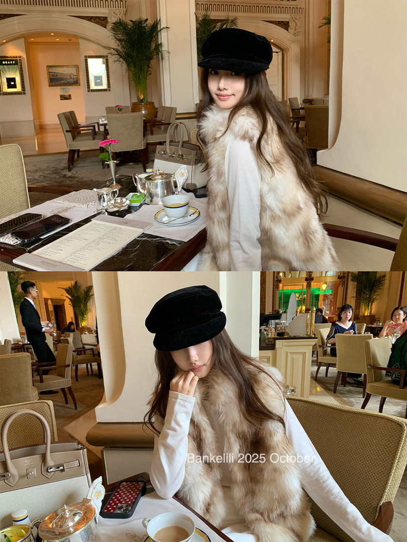 Woman wearing a beige faux fur vest and black hat in a luxury restaurant setting