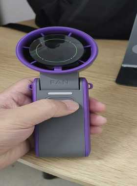 手持小风扇，紫色机身搭配灰色风扇头，成色如图，功能完好。带数