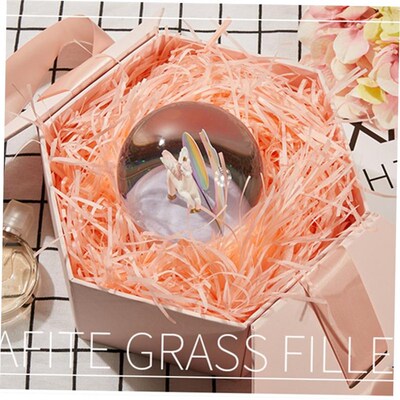 gift lined with shredded paper filling, colored packing box