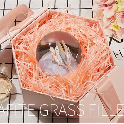 gift lined with shredded paper filling, colored packing box